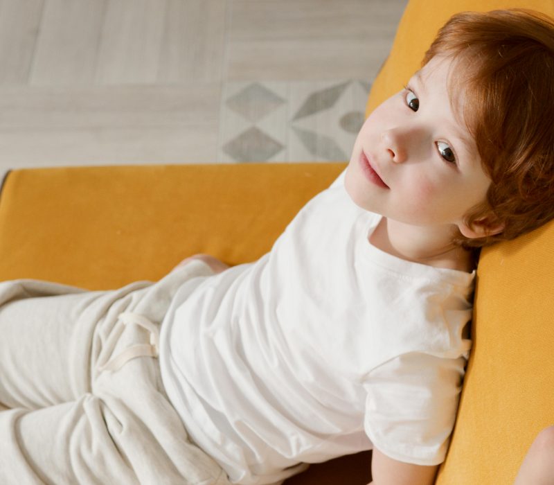 Zdrowie dziecka - chłopiec siedzi na kanapie